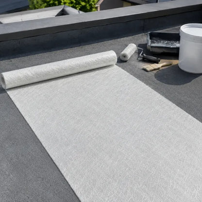 225g fibreglass chopped strand mat rolled out on flat roof with GRP roofing tools and resin